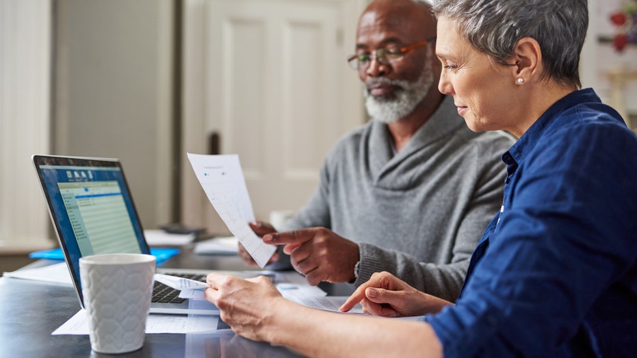 A man and woman working on their finances together at a desk